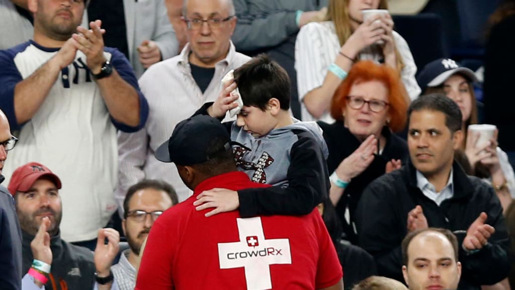Fans applaud as a medical employee carries an injured youngster from the stands after the boy was hit in the head by a piece of Chris Carter's bat. (AP)