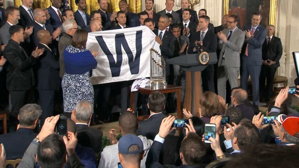 President Barack Obama smiles as Chicago Cubs first baseman Anthony Rizzo  presents him with a 'Chicago' jersey during a ceremony to honor the Cubs in  the East Room of the White House