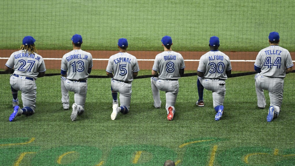 Members of the Blue Jays put their hats back on after the national anthem  during the opening da …