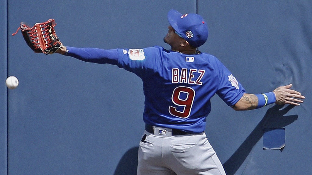 Cubs center fielder Javier Baez can't catch a first-inning drive by the Brewers' Jonathan Villar, who tripled. (AP)