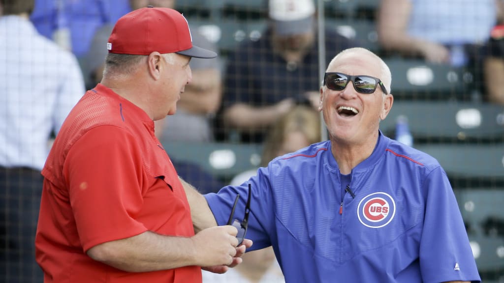Angels manager Mike Scioscia (left) and Cubs manager Joe Maddon laugh before a spring game. (AP)