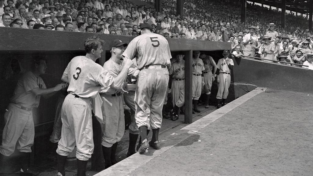 Joe DiMaggio (No. 5) is congratulated after tying the AL hit-streak record in Game 1 of the doubleheader. (Getty)