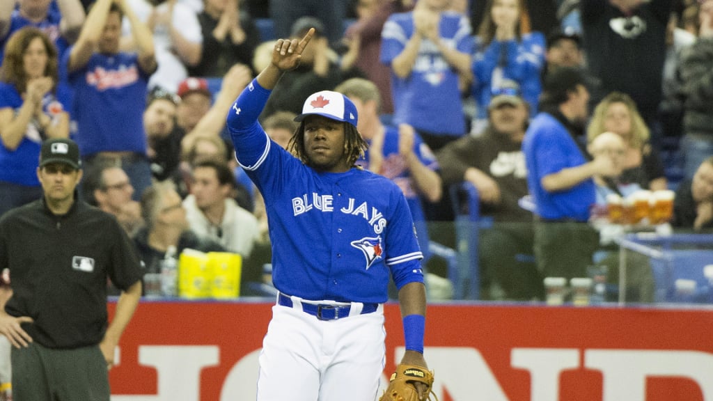 Toronto Blue Jays third baseman Vladimir Guerrero Jr., center, son of former Montreal Expos all-star Vladimir Guerrero, reacts to a standing ovation after coming into a spring training baseball game during the seventh inning against the St. Louis Cardinals, Monday, March 26, 2018, in Montreal. (Ryan Remiorz/The Canadian Press via AP)