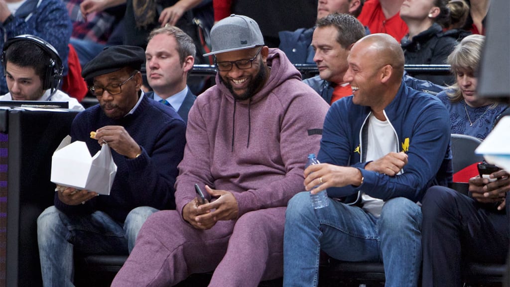 CC Sabathia (center) sits courtside with retired Yankees icon Derek Jeter during an NBA game in Portland, Ore., on Dec. 13. (AP)