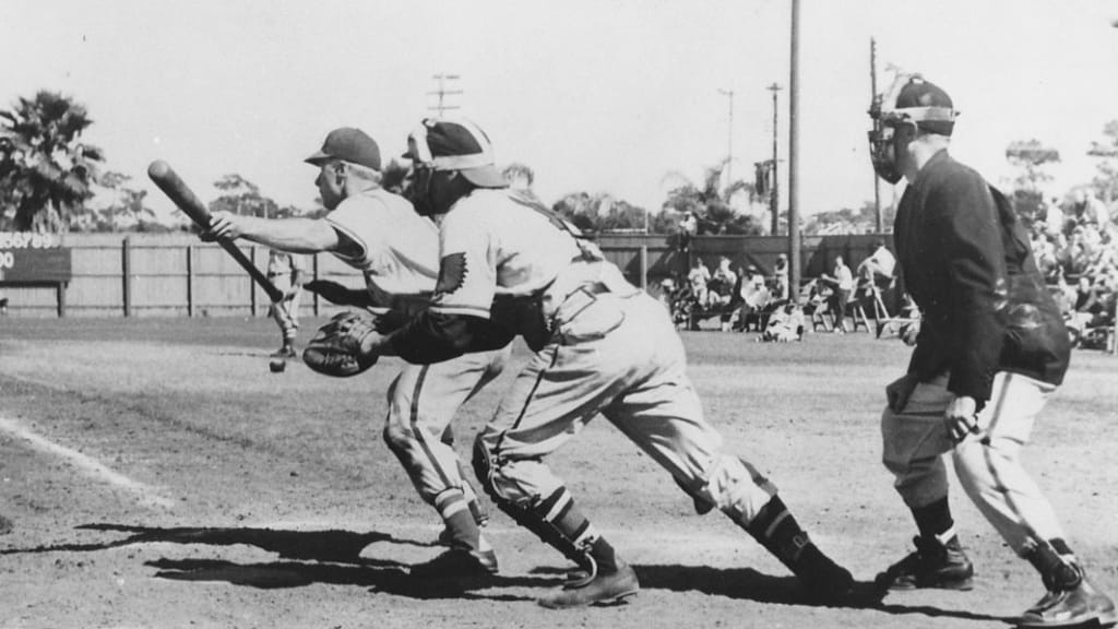 Vintage image taken in Clearwater, Fla., March 26, 1949: Clearwater, Fla., Umpire Art Gore, who had to borrow baseball pants after his blue trousers ripped in the seat, oversees the action as Richie Ashburn of the Philadelphia Phillies lays down a bunt during an exhibition game. Catching is Phil Masi of the Boston Braves. The Phillies won 5-4. (Photo credit: Image courtesy of Bob Warrington)