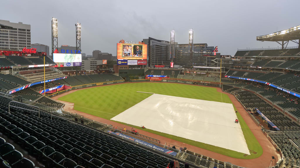 A tarp covers the infield during a delay before a baseball game between the Miami Marlins and the Atlanta Braves, Wednesday, Aug. 1, 2018, in Atlanta. (AP Photo/Todd Kirkland)
