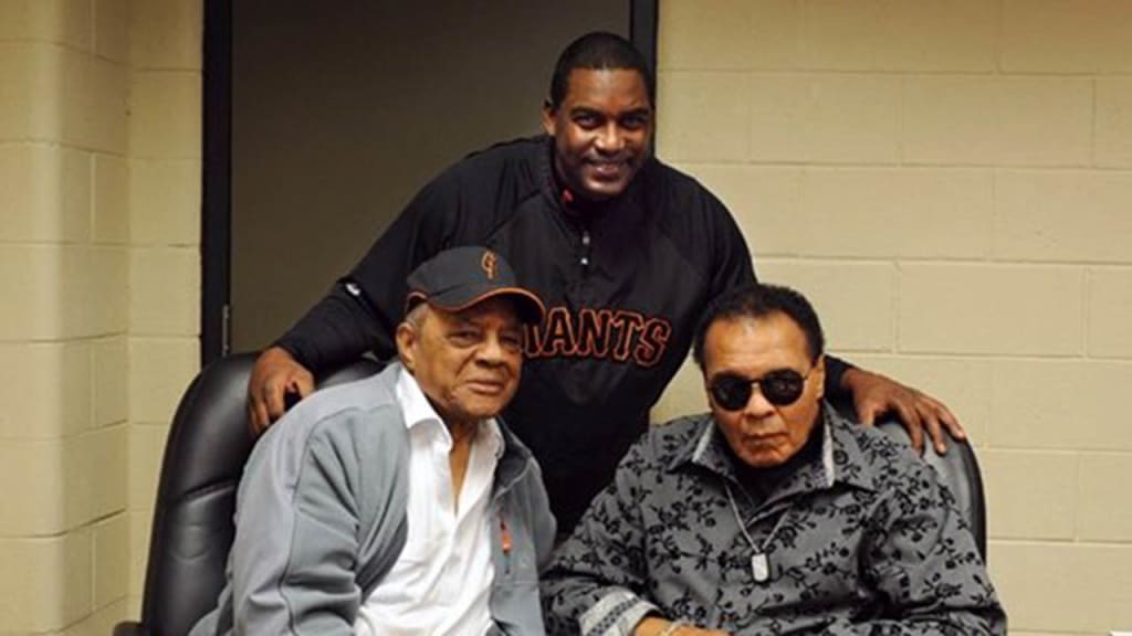 Hensley Meulens (back) and Willie Mays meet with Muhammad Ali during a visit to the Giants' clubhouse. (Giants)