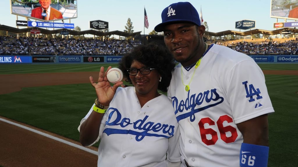 Dodgers outfielder Yasiel Puig and his mother pose on the field at Dodger Stadium.