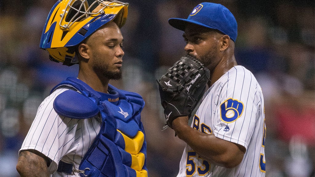 Jhan Marinez meets with catcher Martin Maldonado on the mound during the seventh inning Friday night at Miller Park. (AP)