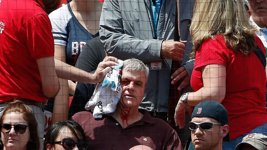 A fan gets medical attention at Fenway after he was struck by George Springer's broken bat. (AP)