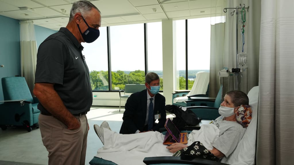 MLB Commissioner Rob Manfred visits with a patient at MercyOne Medical Center in Dubuque, Iowa.