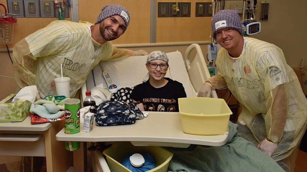Tyler Chatwood and Nick Hundley visit with a patient at Children's Hospital Colorado (Matt Dirksen/Rockies)