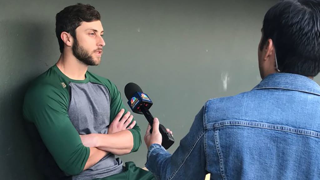 Dustin Fowler speaks to the media in the dugout on Monday, his first official day at A's Spring Training.