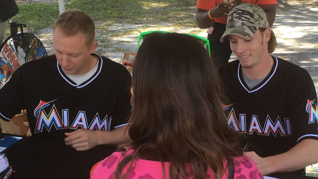 Scott McGough (left) and Adam Conley sign autographs at a Marlins Play Ball Week caravan event. (Joe Frisaro/MLB.com)