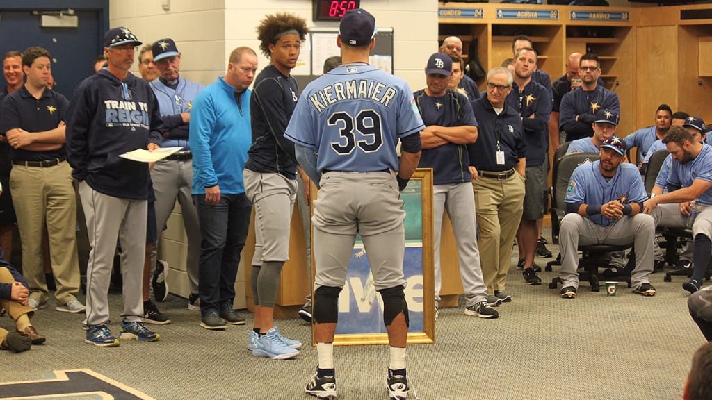With their teammates gathered around, Chris Archer presents his painting to Kevin Kiermaier.