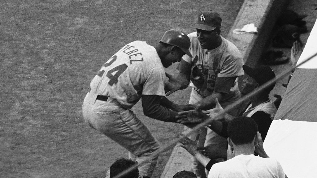 Tony Perez gets a warm welcomes as he arrives in the National League dugout after his game-winning home run in the 15th inning. (AP)