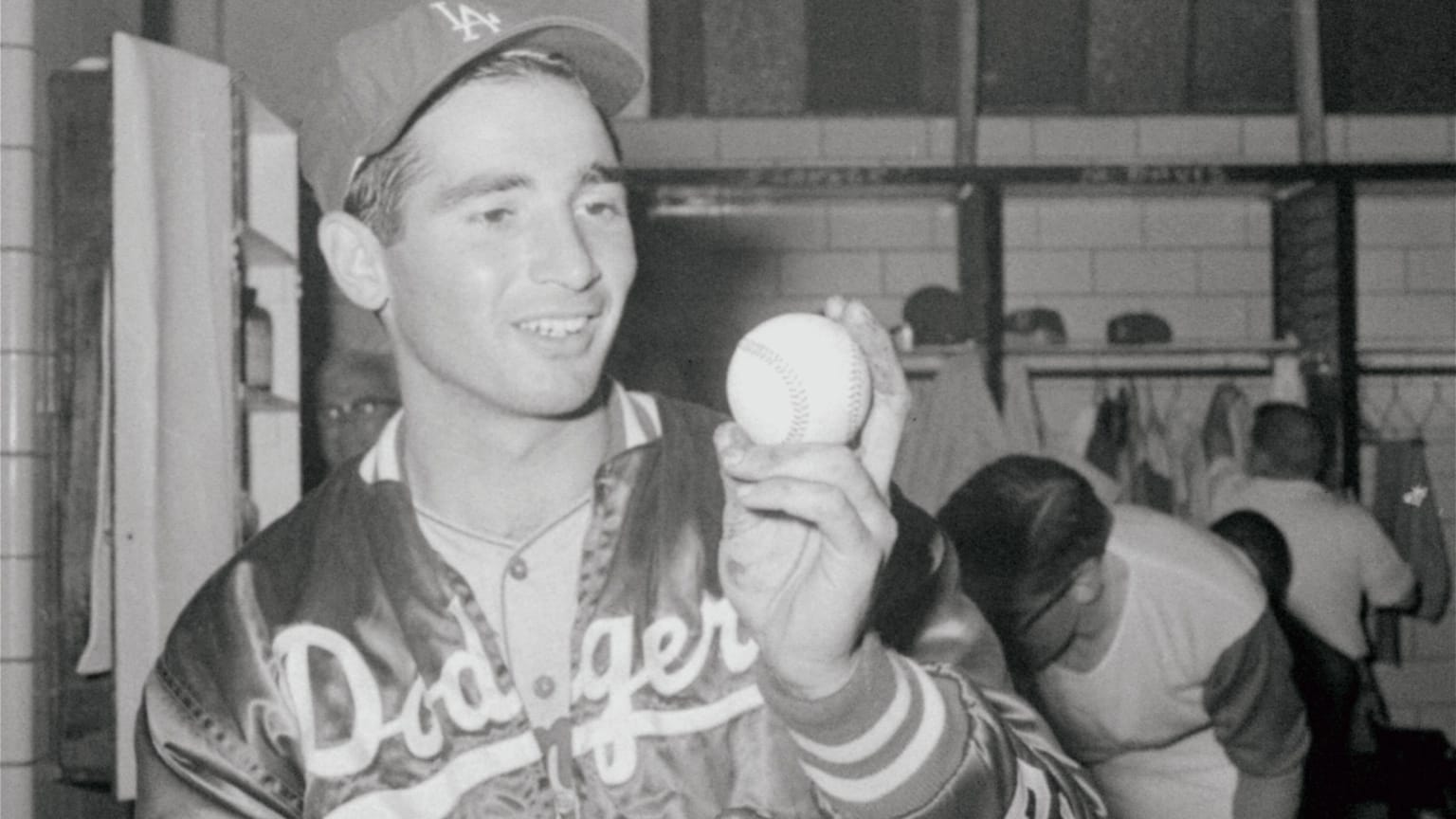 Sandy Koufax holds up a baseball in the Dodgers clubhouse