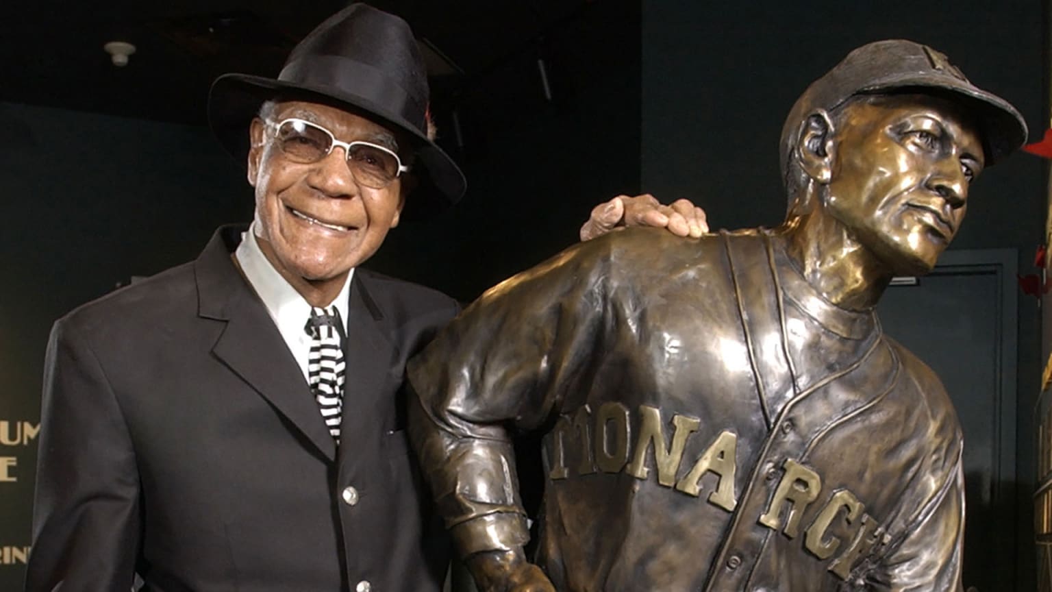 Buck O'Neil poses with a statue of himself