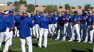 Munenori Kawasaki leads Cubs players (wearing headbands) in an