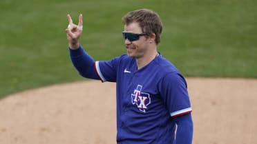 Texas Rangers third baseman Brock Holt (16) blows a bubble during a  baseball game against the