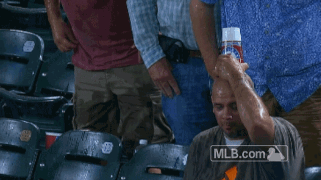 Fan protects himself from rain with souvenir beer cup