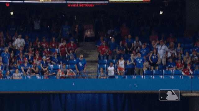 Kevin Pillar climbs the wall for a catch