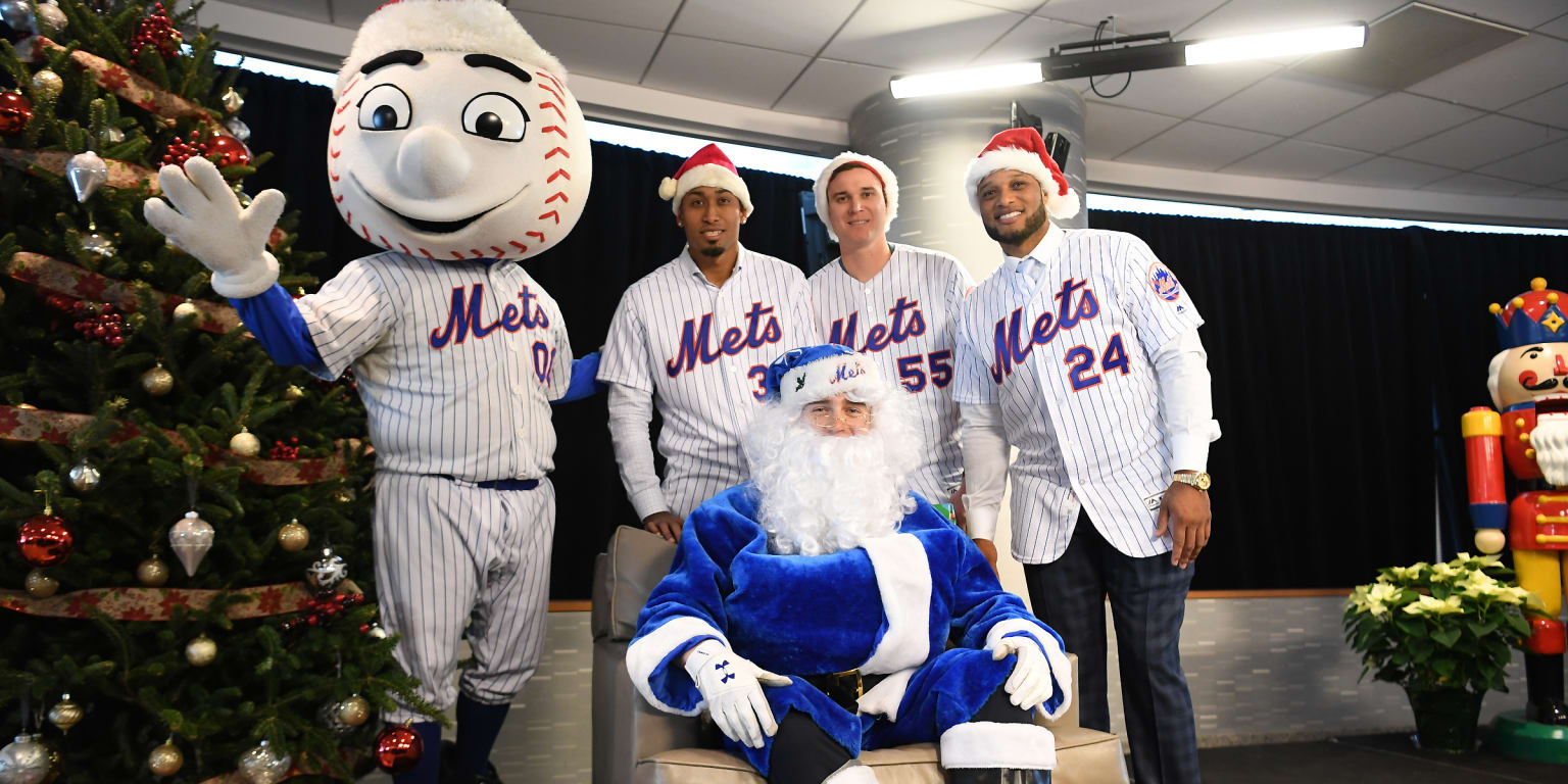 New York Mets outfielder Brandon Nimmo, center, dressed as Santa