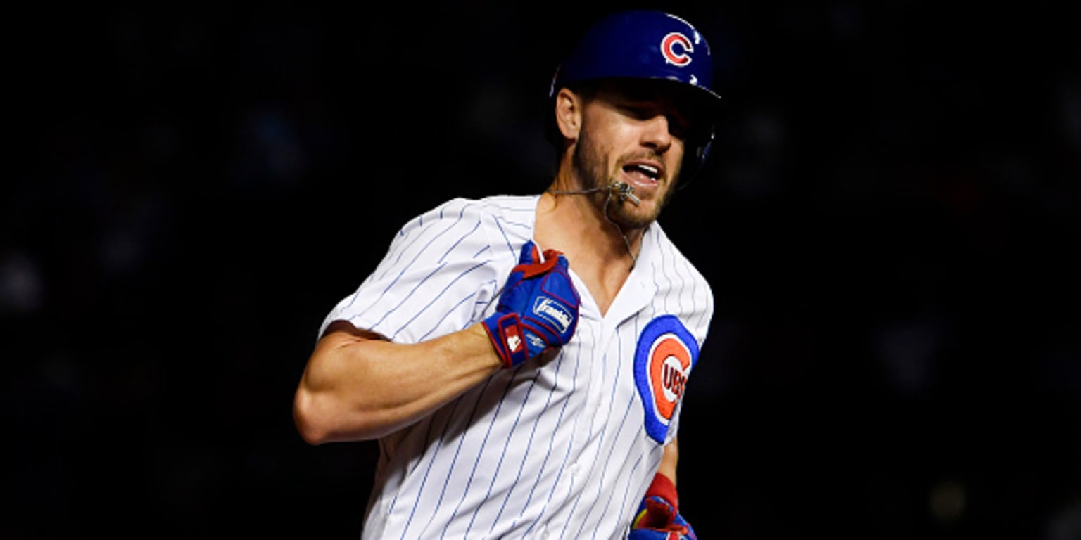 Patrick Wisdom of the Chicago Cubs pulls on his jersey in