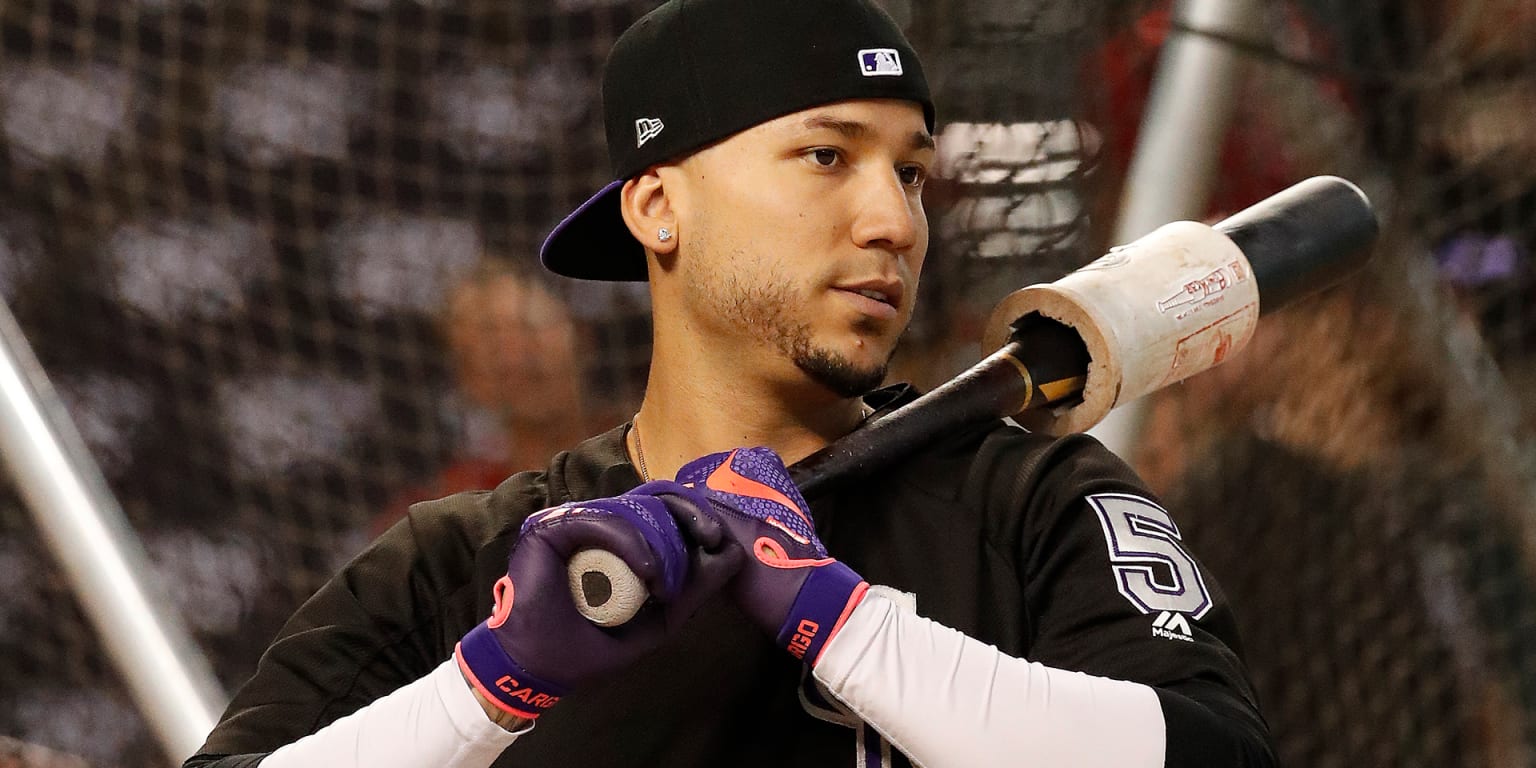 Dante Bichette of the Colorado Rockies looking on holding a bat