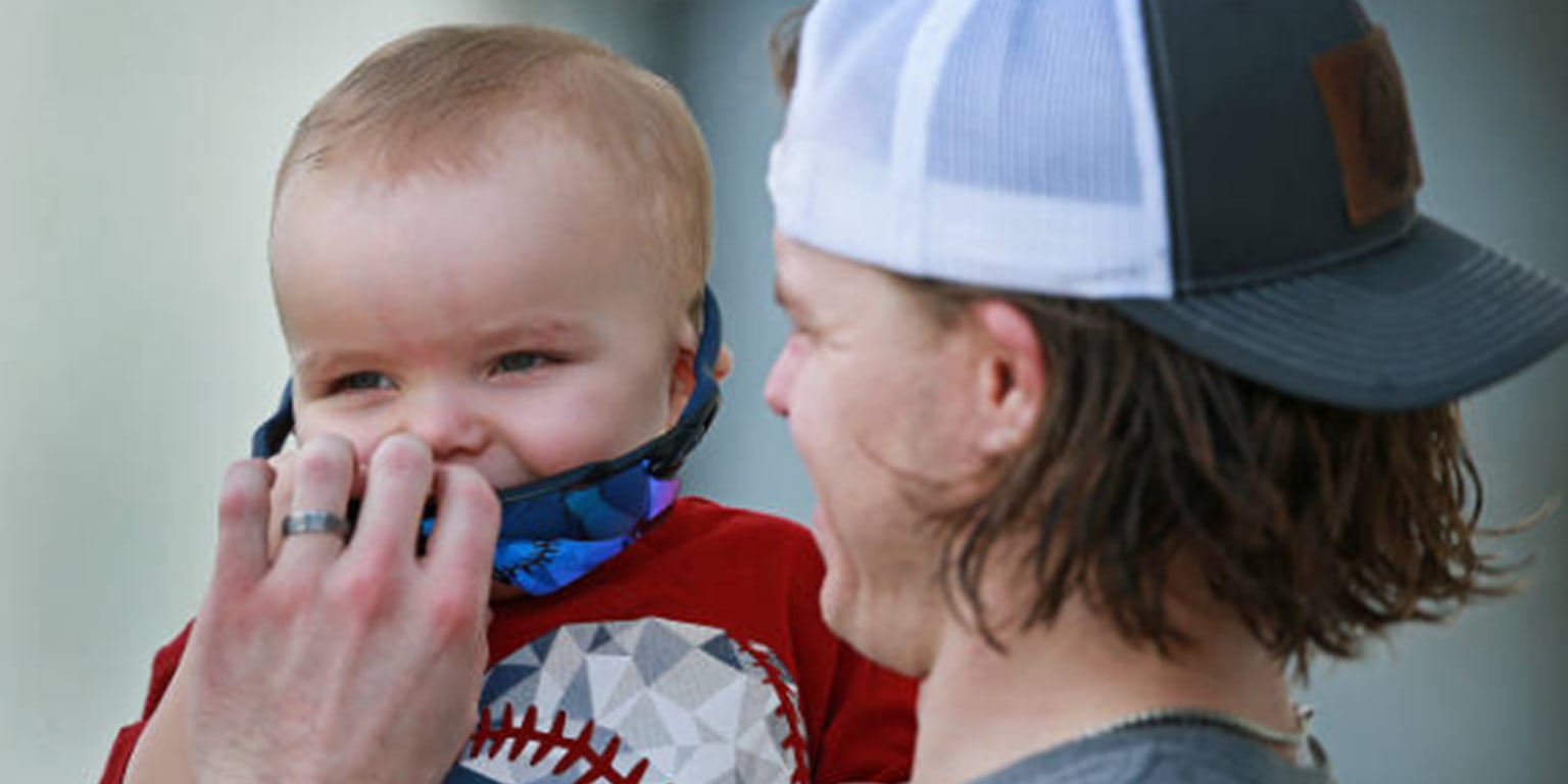 Boston Red Sox's Brock Holt reaches for his son Griffin as he arrives back  in Boston with his family, Monday, Oct. 29, 2018. The Red Sox defeated the  Los Angeles Dodgers on