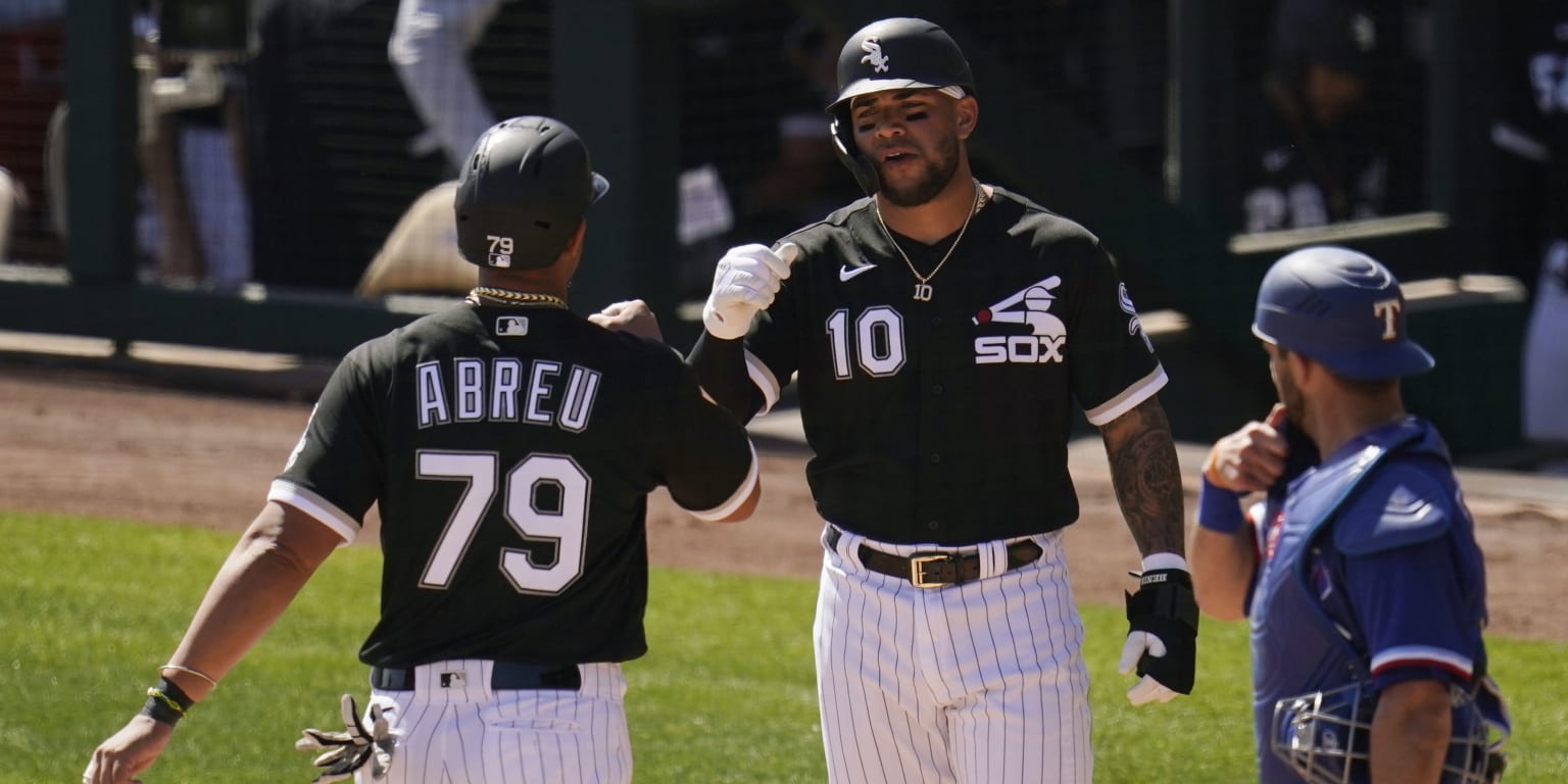 Jose Abreu and Yoan Moncada of the Chicago White Sox bump fists on the field
