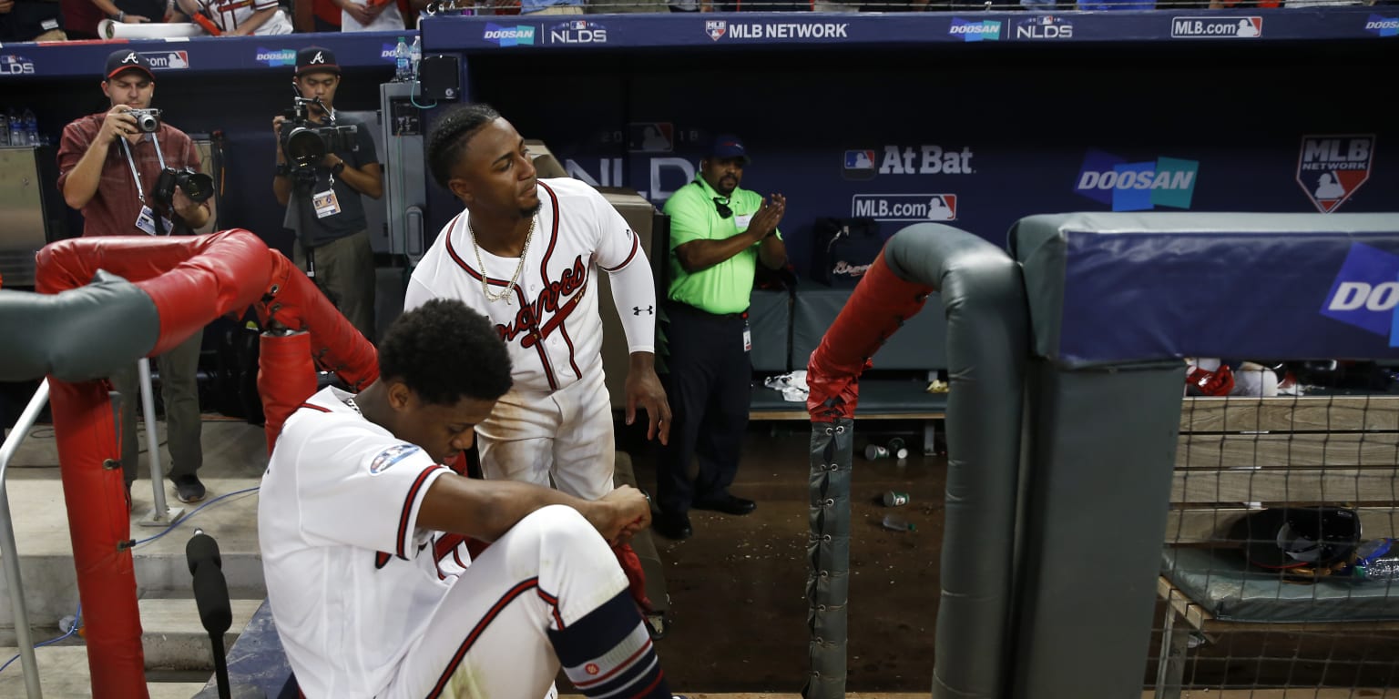 Atlanta Braves' Ozzie Albies has his chain in his teeth after diving into  third base on a long fly ball by Ronald Acuna Jr. against the San Francisco  Giants during the first