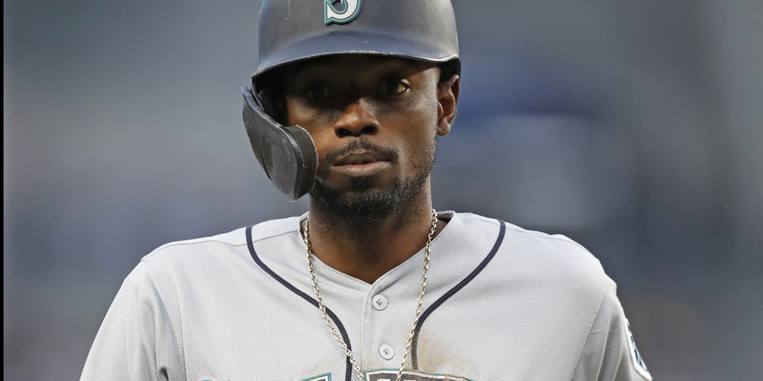 Los Angeles Dodgers' Dee Gordon holds on to his helmet as he