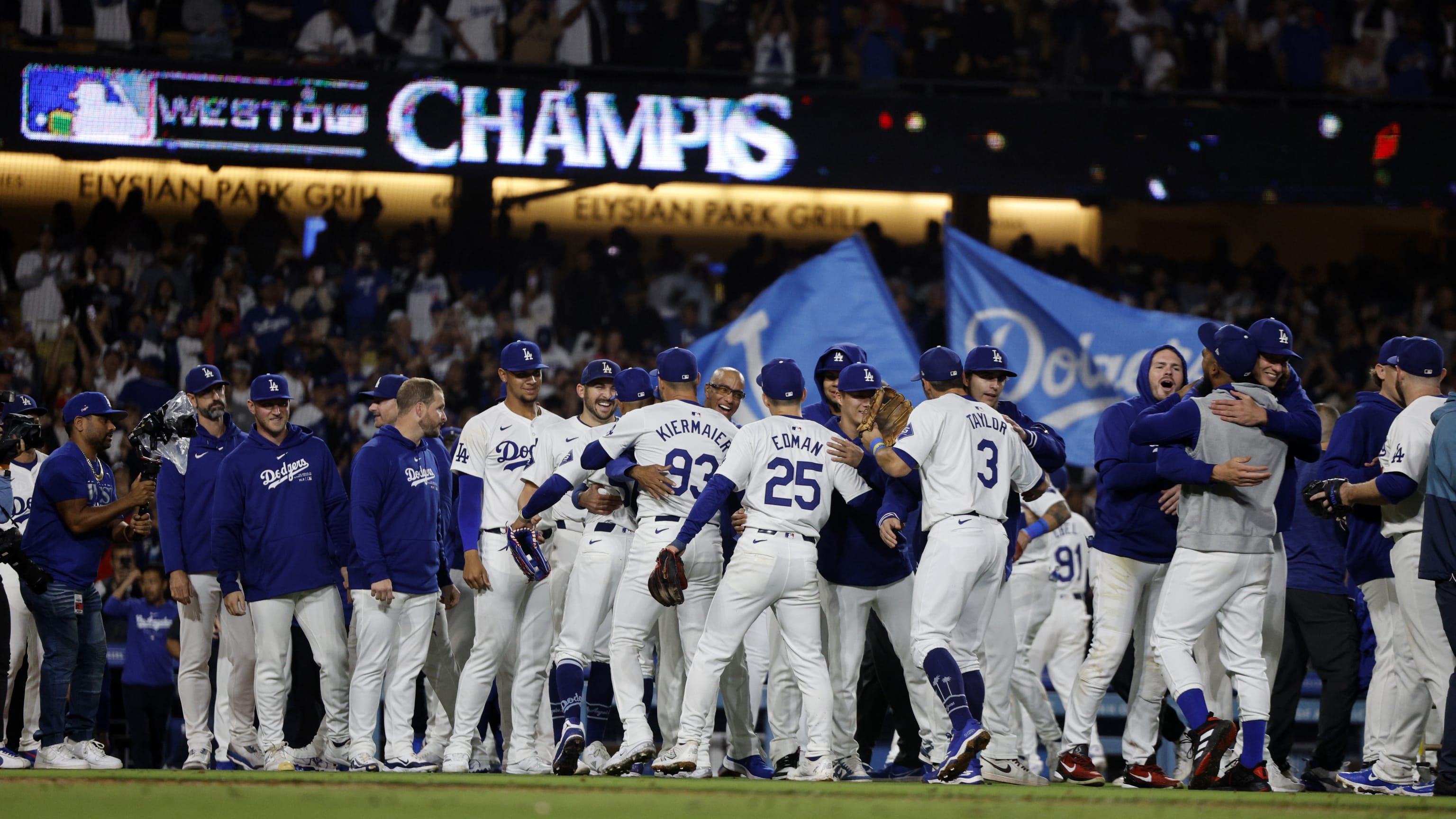 Los Angeles Dodgers celebrating an NL West division championship beneath a West Division Champs scoreboard