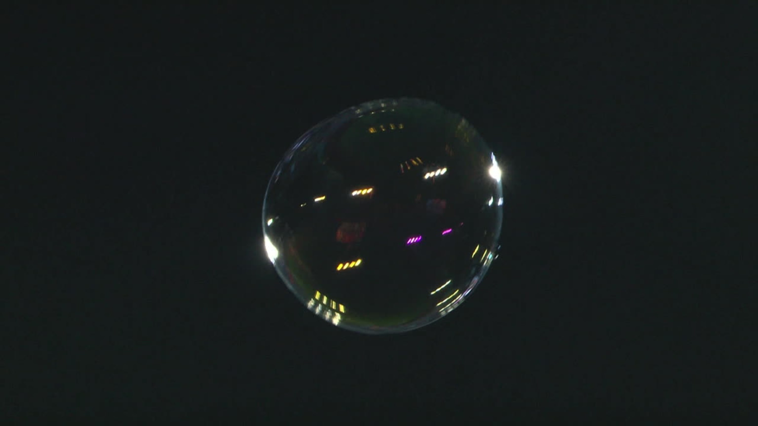 A bubble floats in the night sky