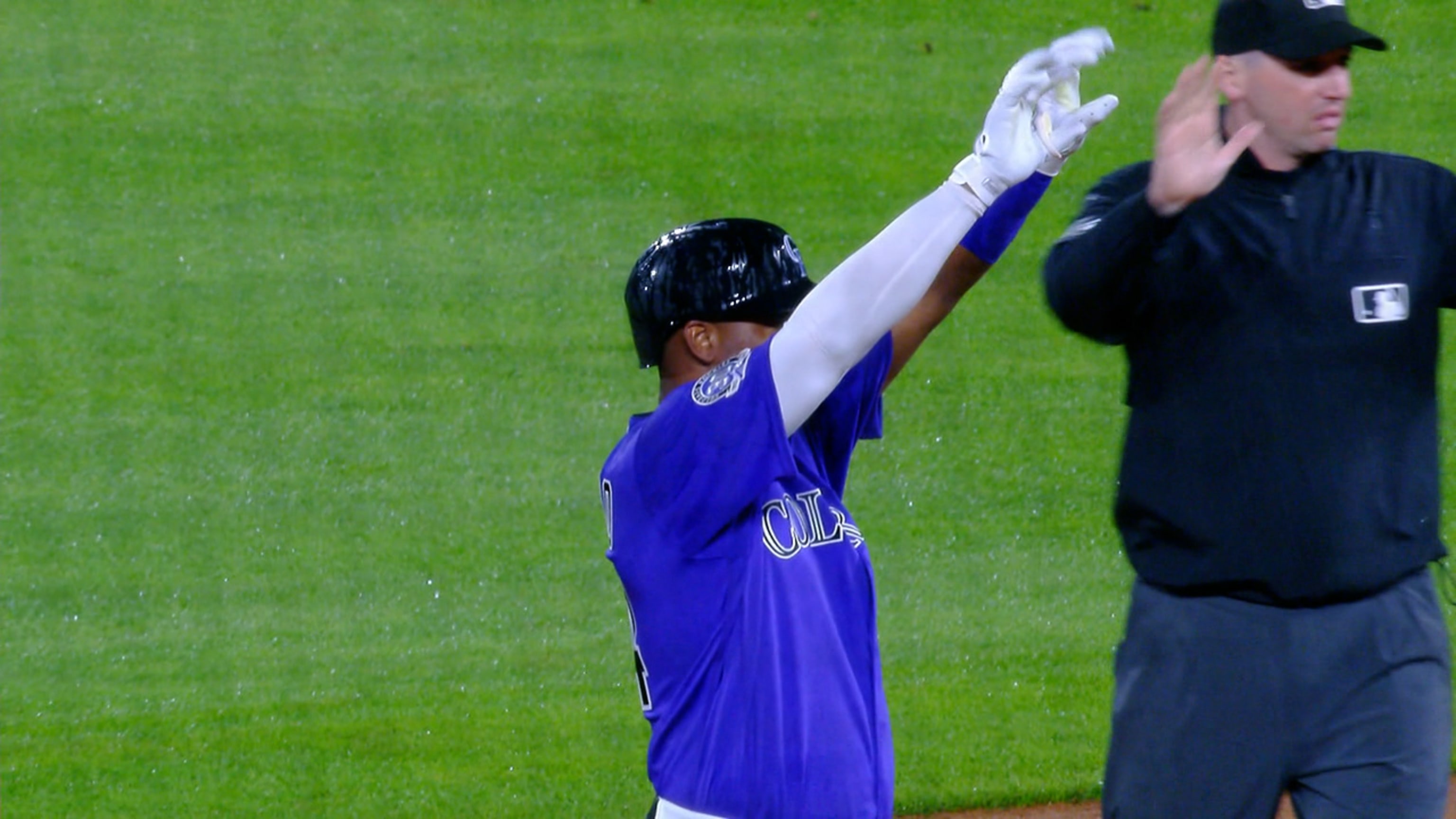 Colorado Rockies' Ryan McMahon, left, gestures to the dugout after hitting  a triple to drive in two runs as Cincinnati Reds third baseman Mike  Moustakas looks on in the sixth inning of