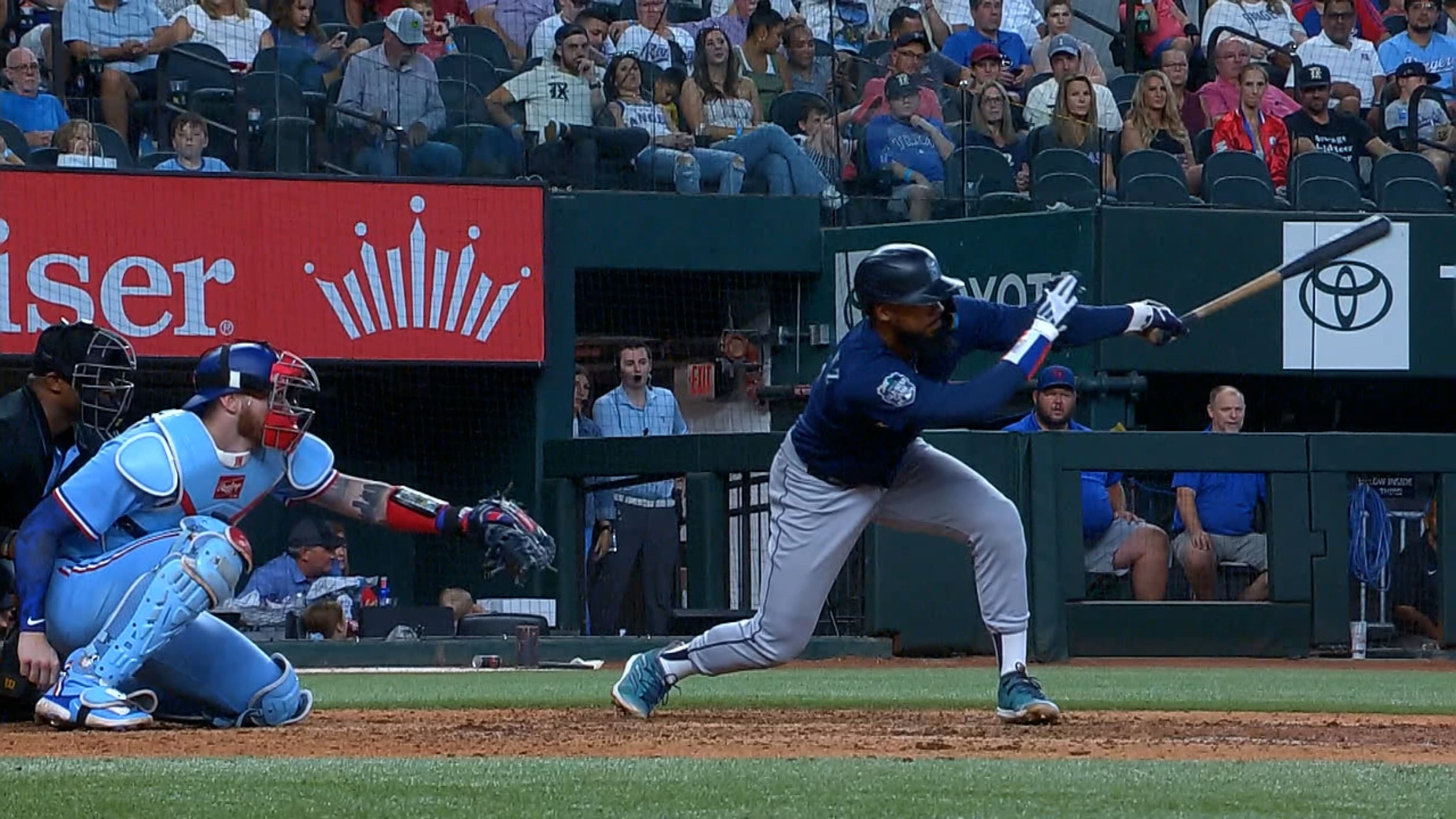 Seattle Mariners' J.P. Crawford (3) holds a trident after hitting a home  run as he is greeted by teammate Teoscar Hernández, left, against the  Kansas City Royals during the first inning of