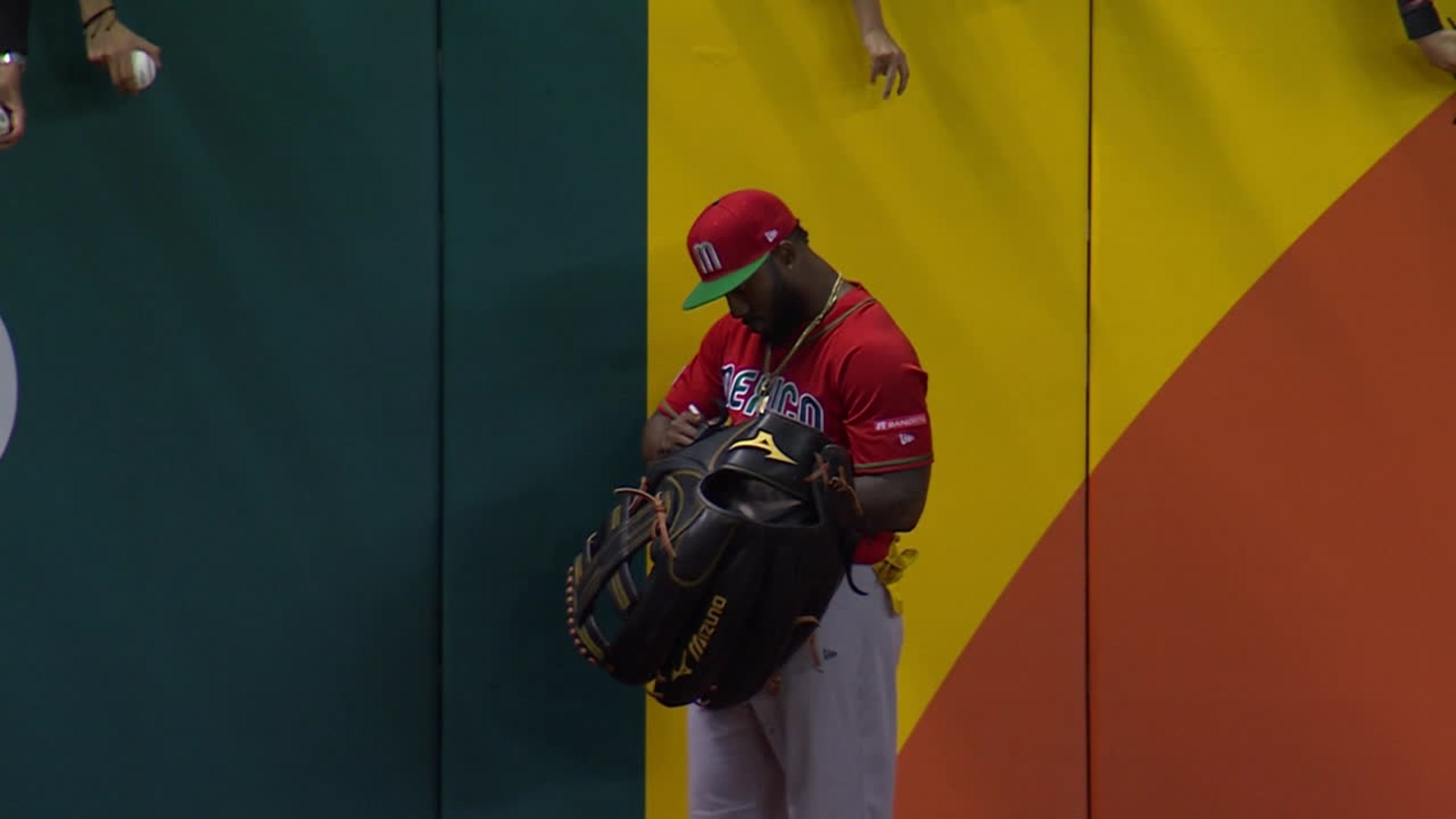 Mexico left fielder Randy Arozarena (56) signs autographs on the warning  track during a pitching change in the seventh inning of a World Baseball  Classic game against Japan, Monday, March 20, 2023