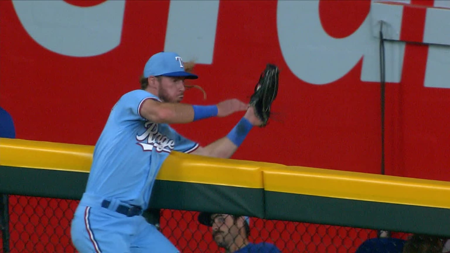 Texas Rangers center fielder Travis Jankowski reaches up to catch