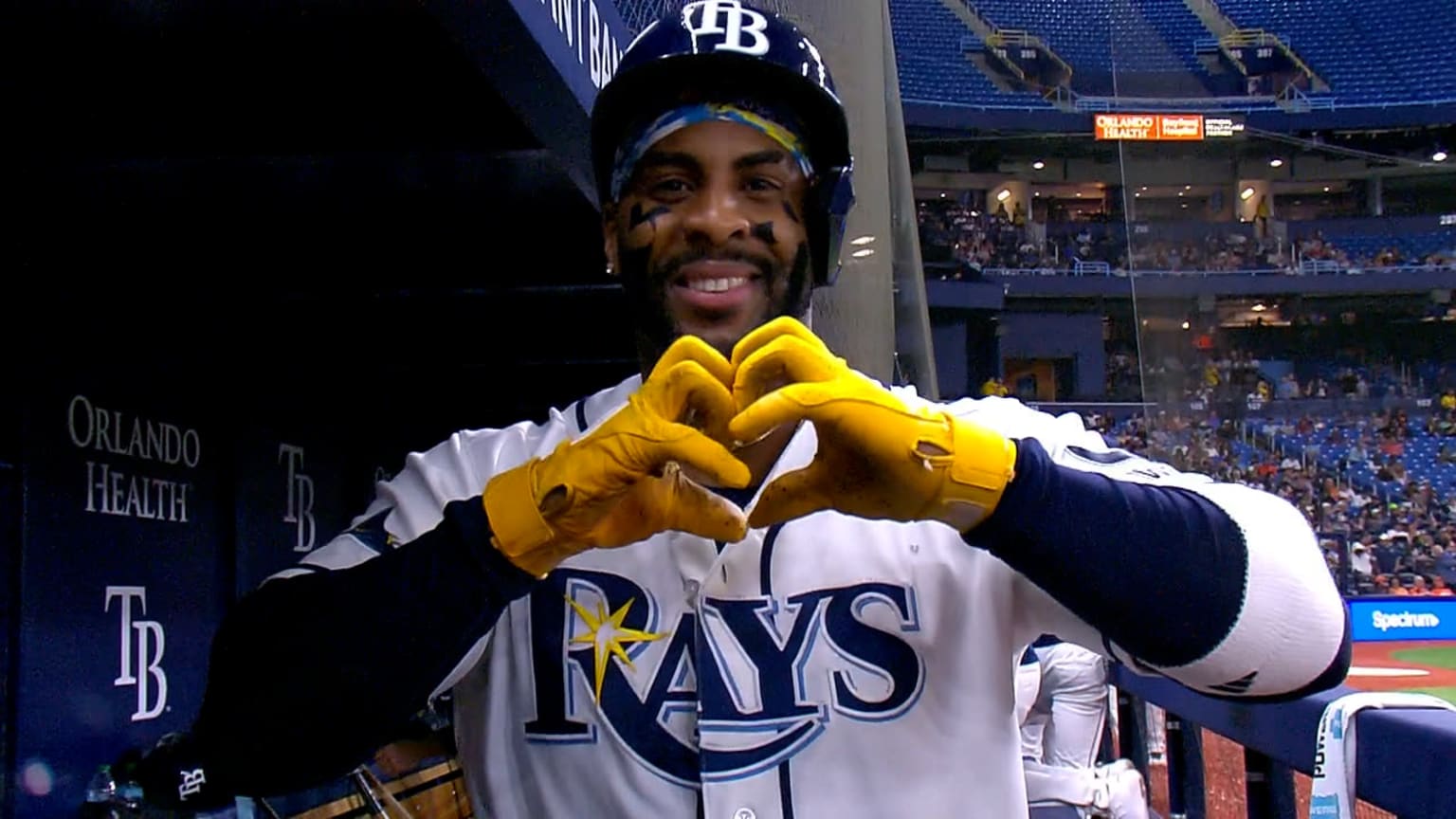 Yandy Díaz celebrating with yellow gloves in a Tampa Bay Rays uniform, documentary photograph from MLB coverage
