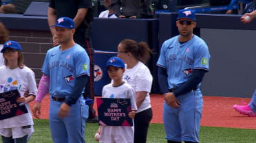 Blue Jays players line up with children and mothers 