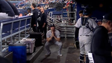 Gerrit Cole stays loose by doing squats in the dugout