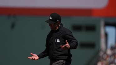 Umpire Chris Guccione jumps over Ryan McMahon