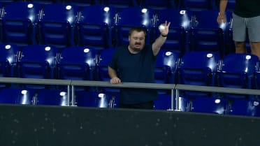 A fan negotiates over Victor Mesa's HR ball