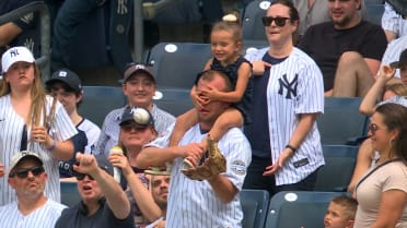 Fan catches ball while daughter covers his eyes