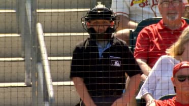 Kid umpire helps call the game behind the backstop