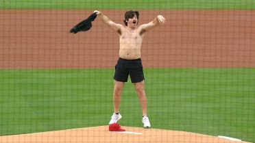 Member of the 'Tarps Off' crew throws out first pitch