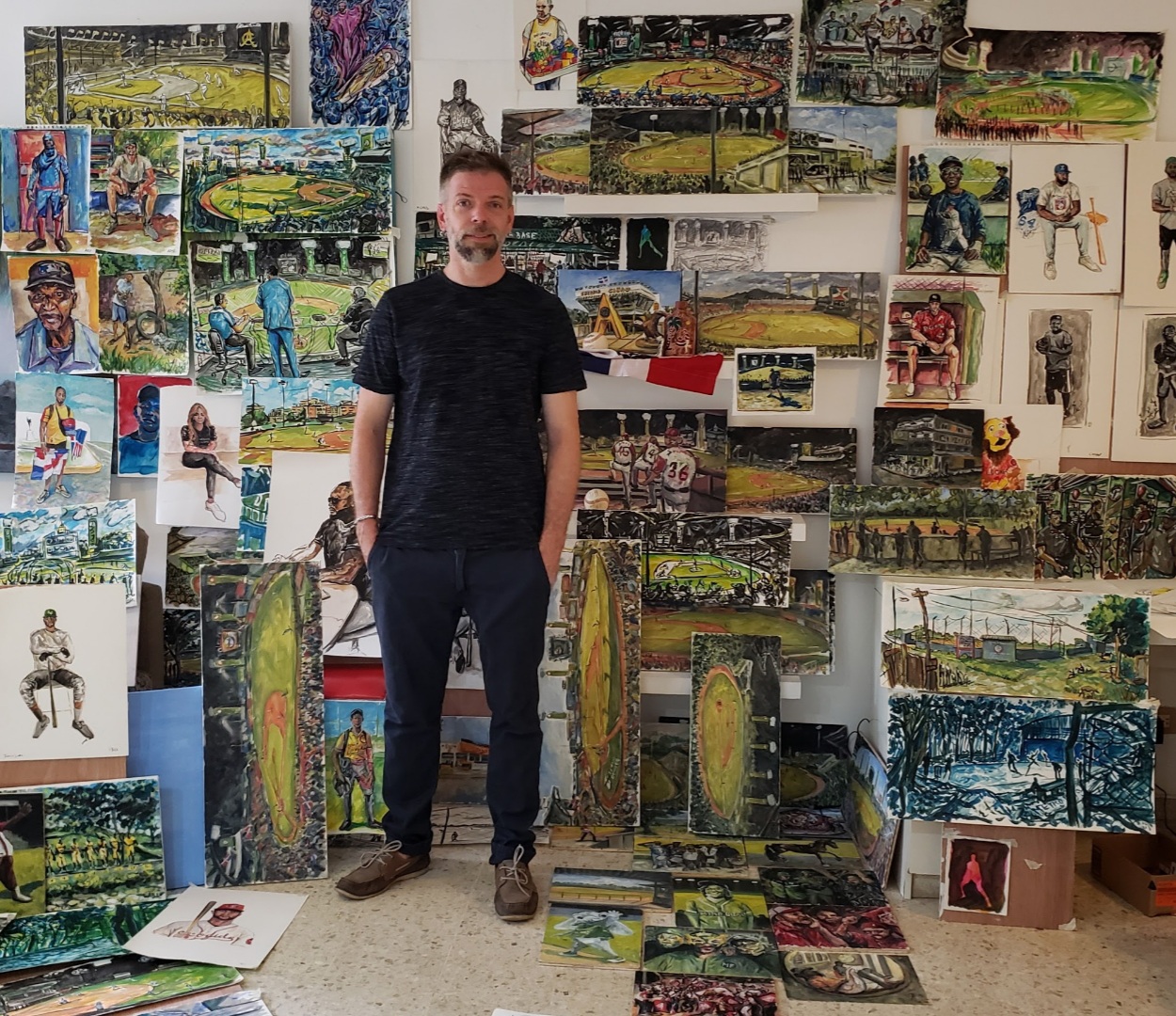 Andy Brown surrounded by his "El Arte de Beisbol" paintings.