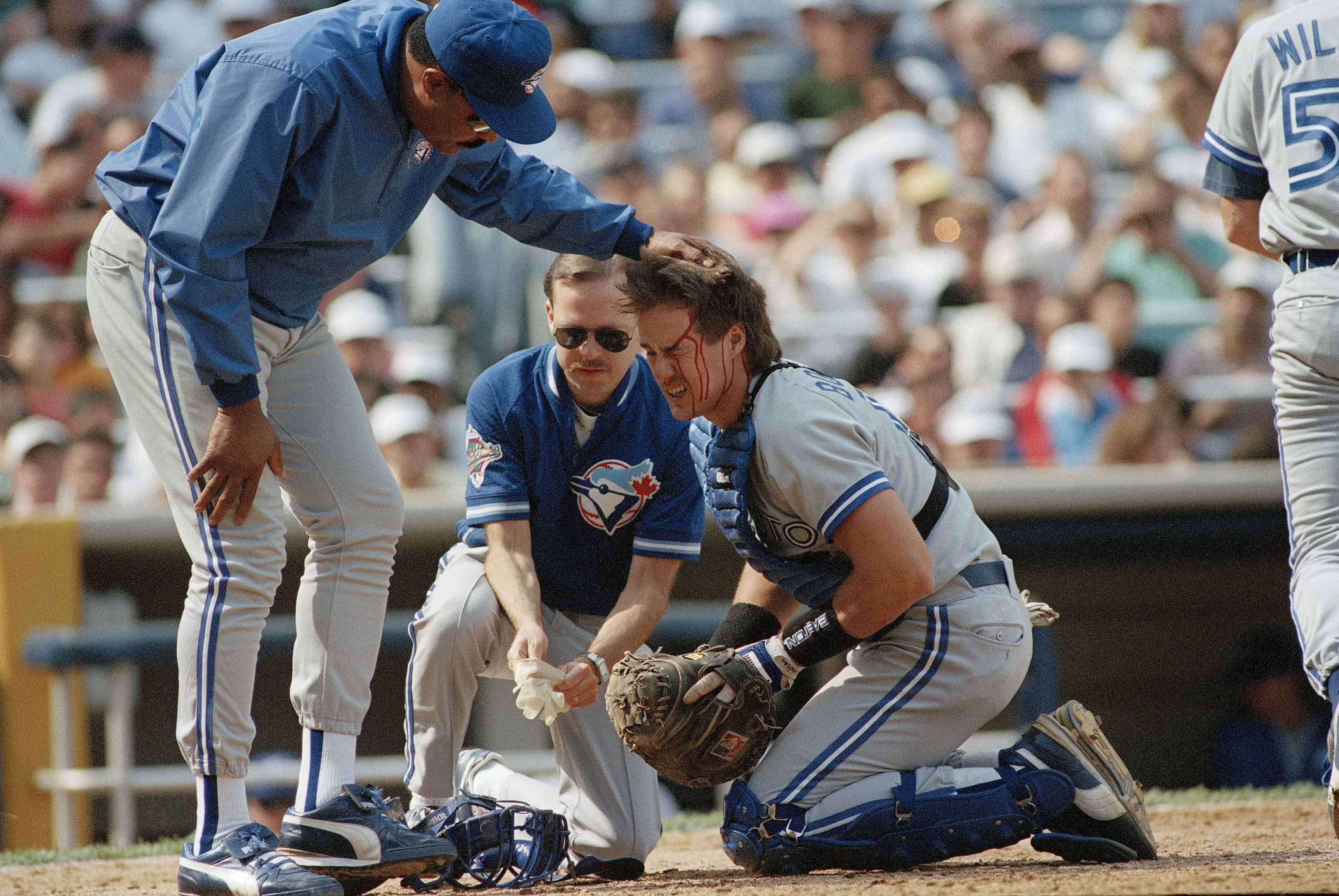 Blue Jays manager Cito Gaston checks on Pat Borders after he was hit by the bat of the Yankees' Gerald Williams at Yankee Stadium on May 15, 1993.