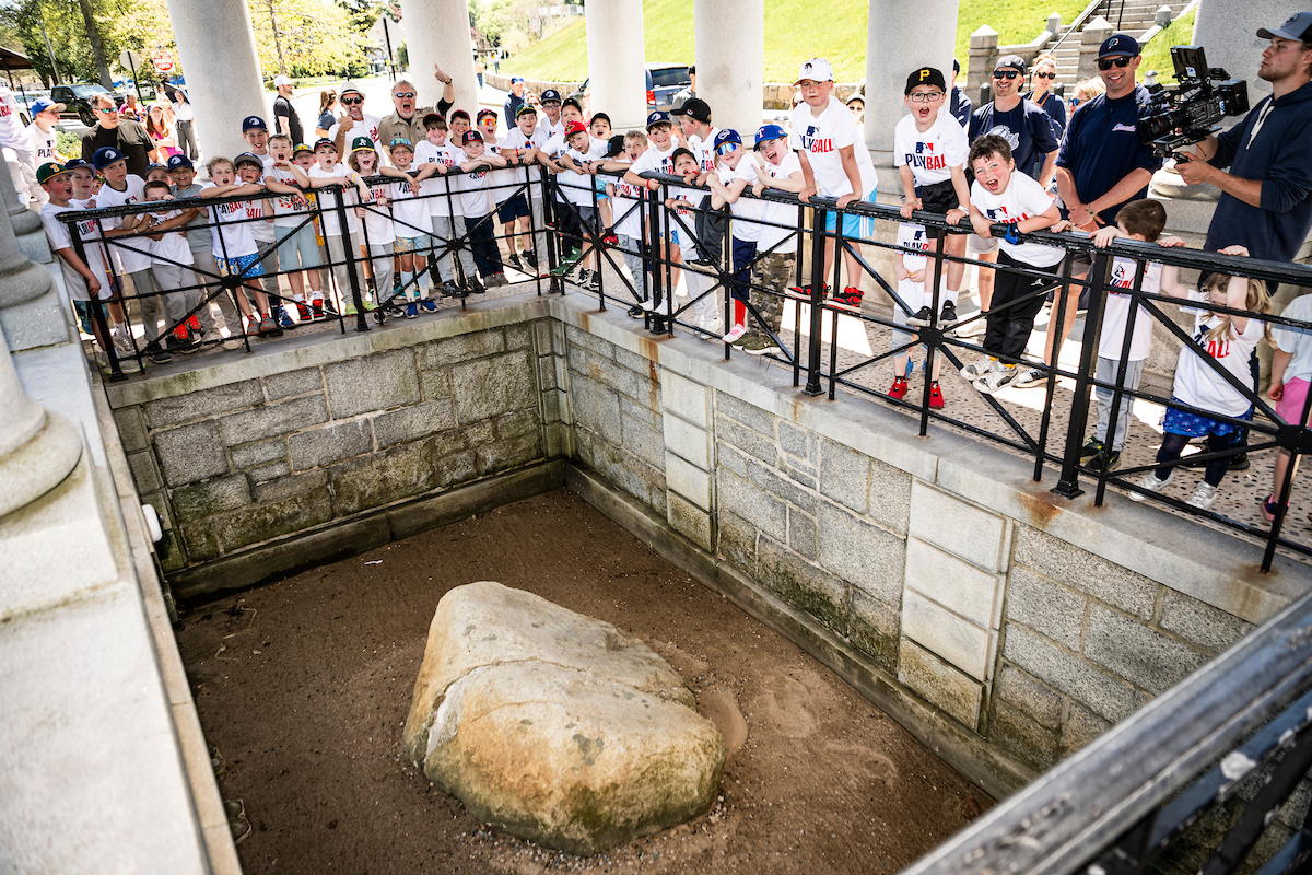 Lowe poses for a group photo with attendees near Plymouth Rock during Play Ball event.